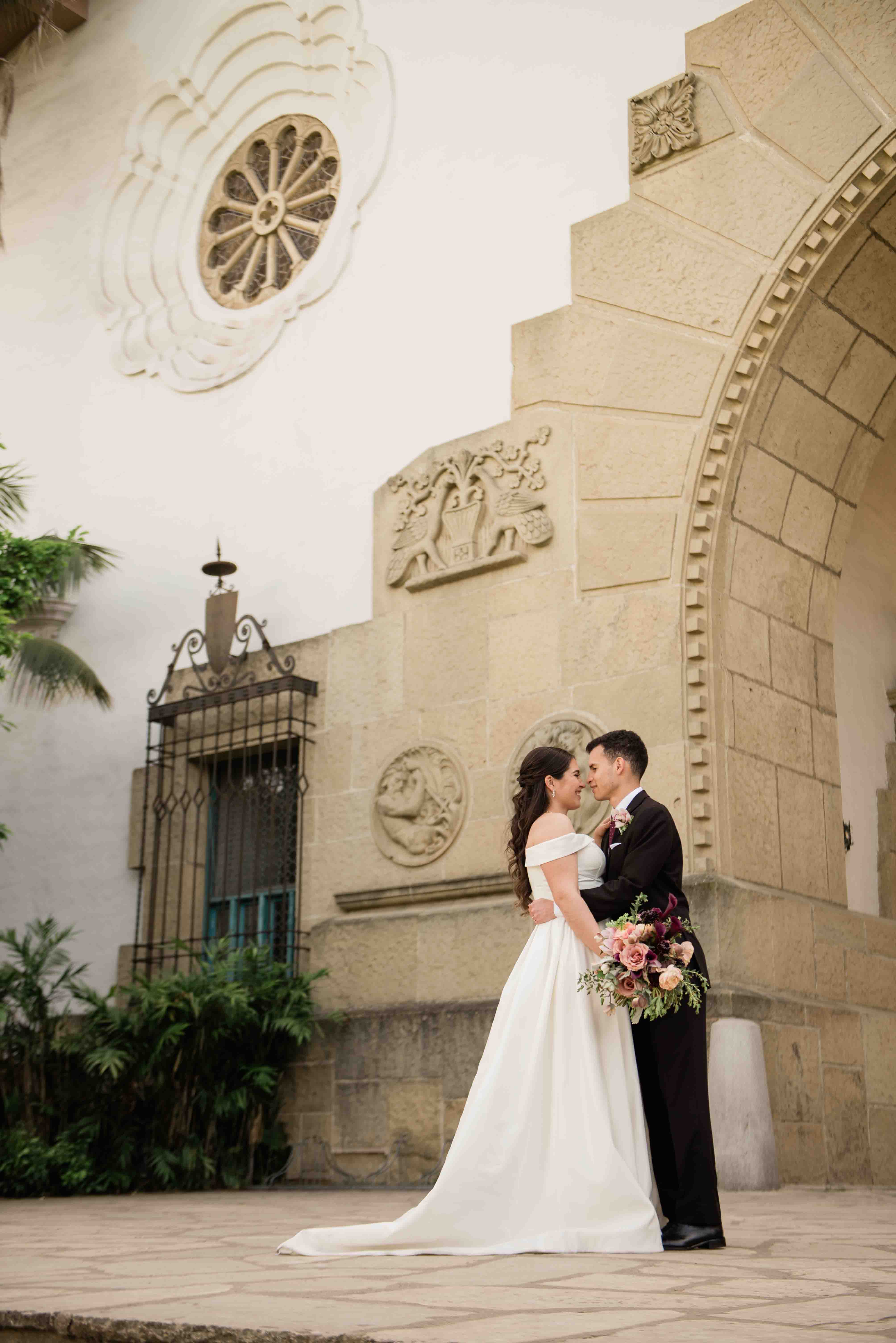 Bride and groom laughing on stairs of large archway of the Santa Barbara Courthouse