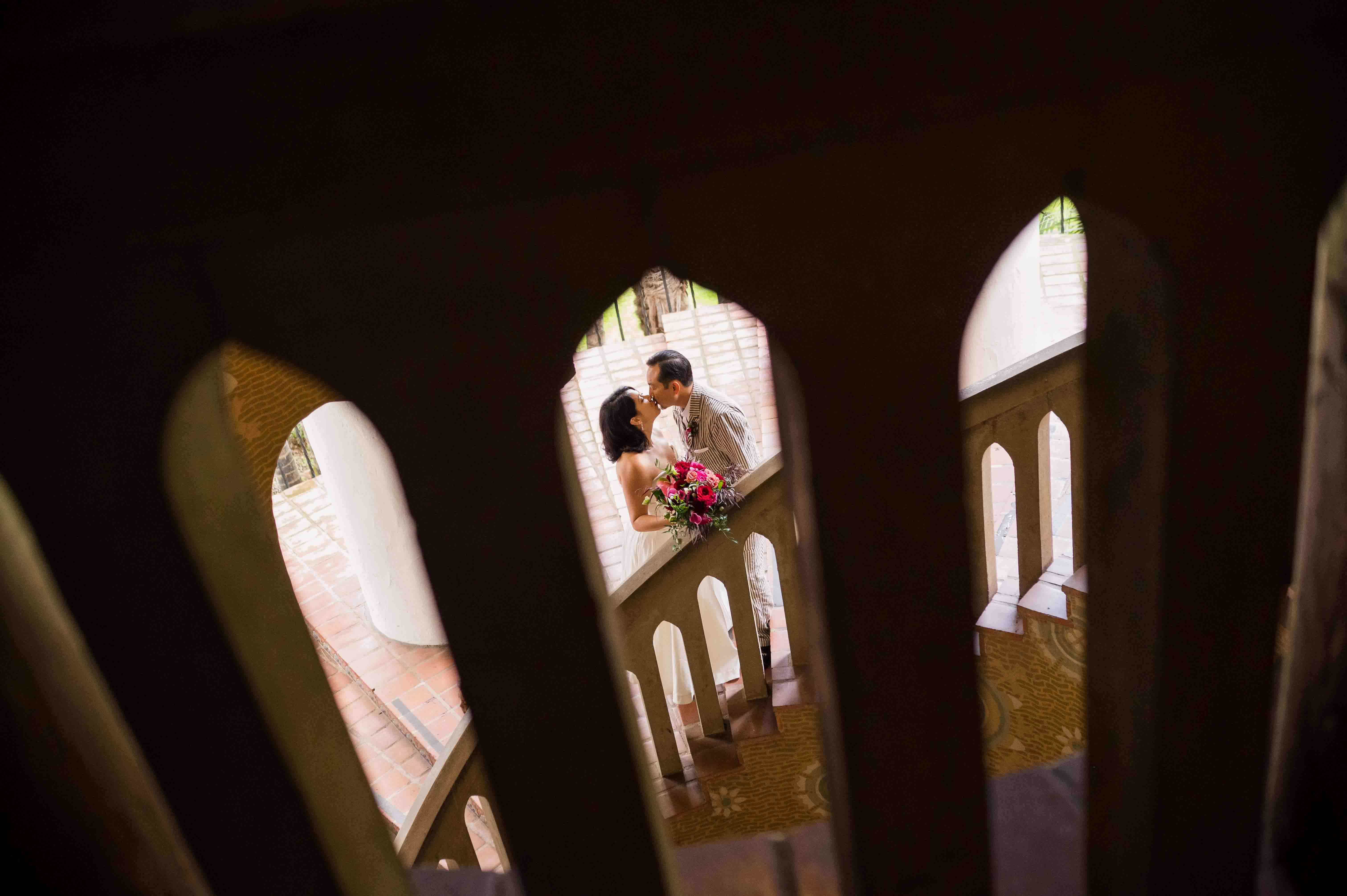 Bride and groom kissing on the circular staircase of Santa Barbara Courthouse
