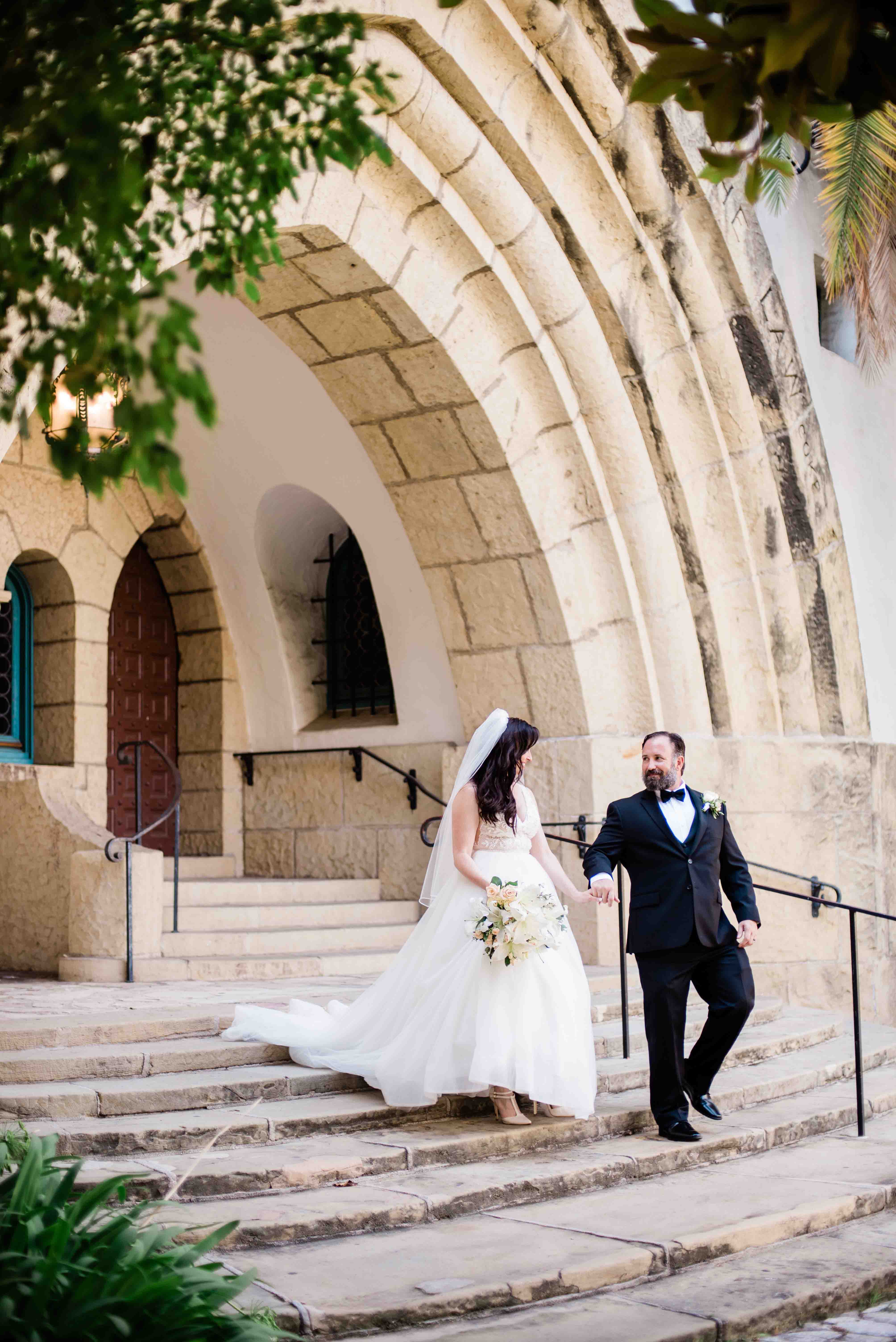 groom leading bride down stairs