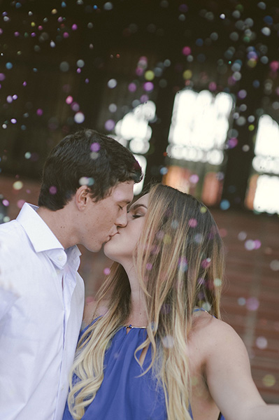 caucasian couple kissing as confetti falls around them