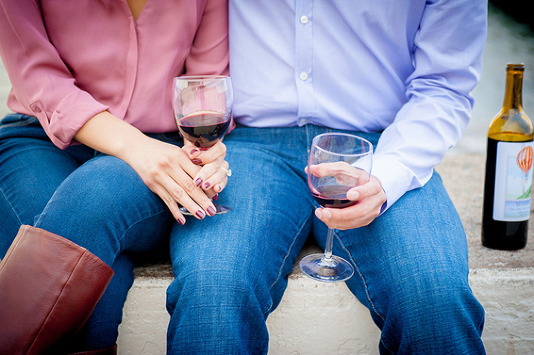 closeup of couple's hands holding wine glasses 