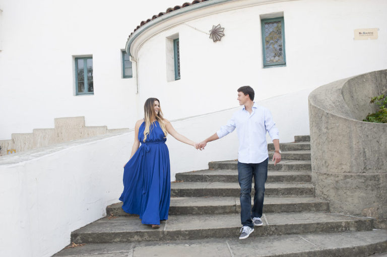 Caucasian couple holding hands walking down stairs of Santa Barbara courthouse
