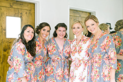 bride and bridesmaids posing in matching floral robes