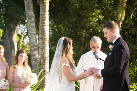 bride putting wedding band on groom