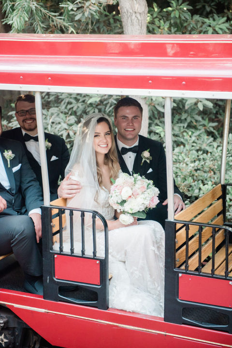 bride and groom sitting on kids train