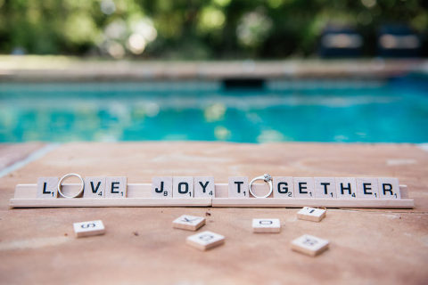 Photos of wedding rings spelling out the word Love Joy Together in Scrabble tiles