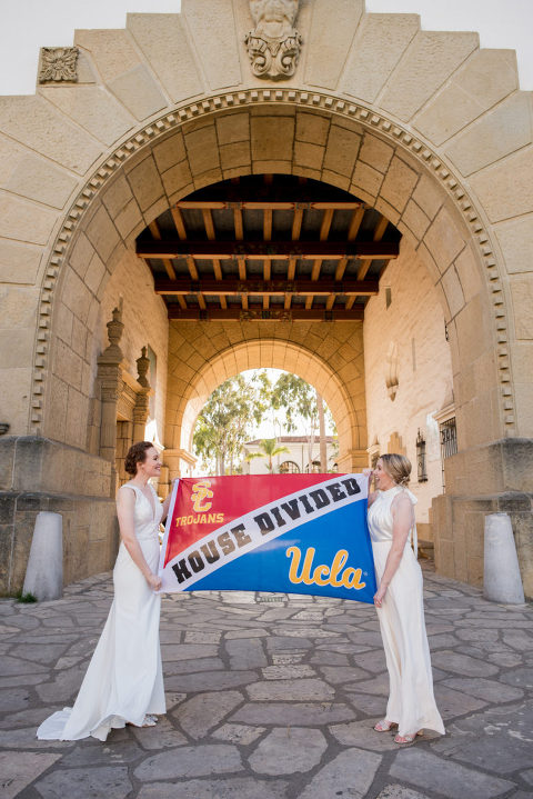 two brides with their UCLA and USC flag at the Santa Barbara courthouse Mural Room