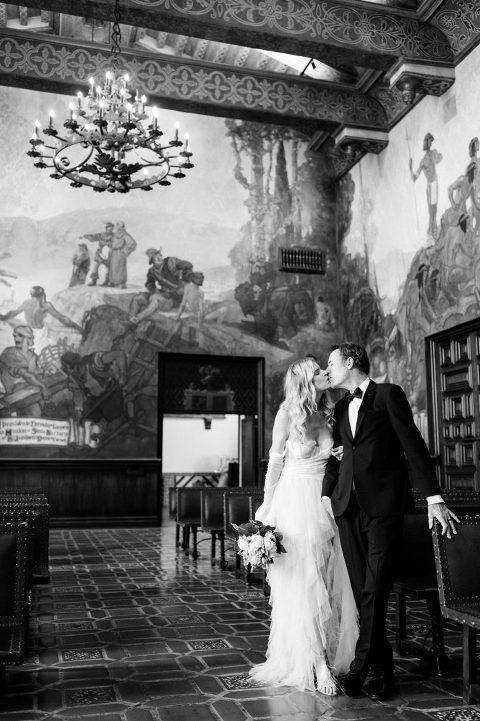 bride and groom kissing under chandelier at santa barbara courthouse
