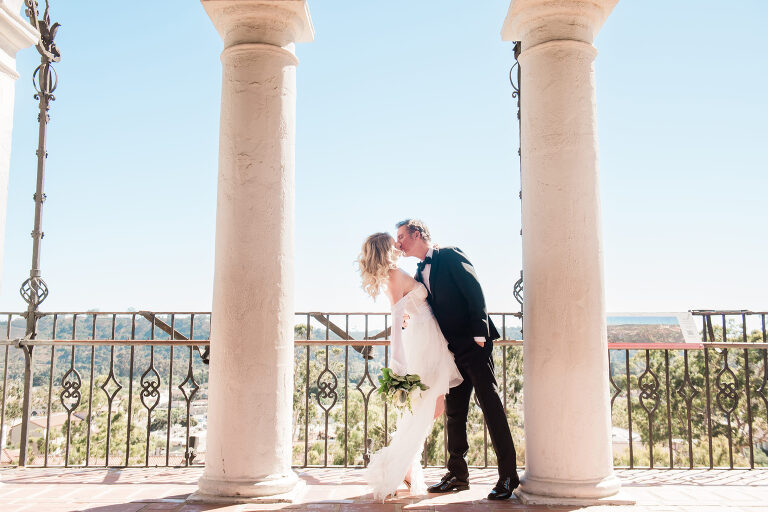 Caucasian bride and groom kissing in the clock tower of the Santa Barbara Courthouse