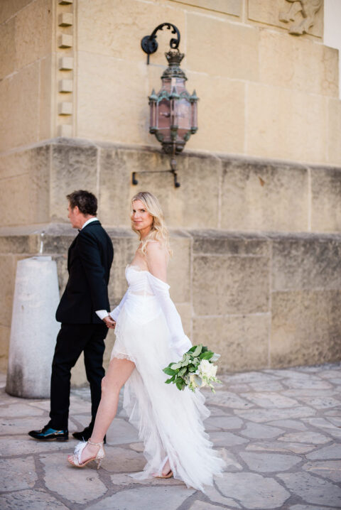 Bride and groom walking under large lantern of the Santa Barbara Courthouse