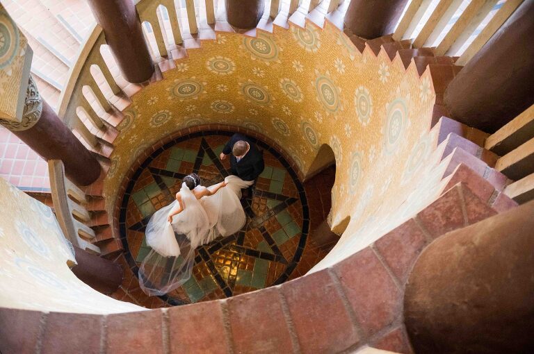 Bride twirling around at bottom of Santa Barbara Courthouse circular staircase