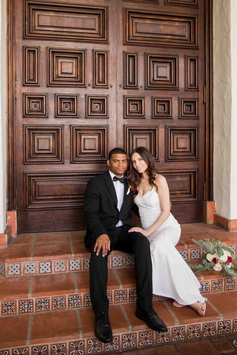 bride and groom sitting on steps of santa barbara courthouse