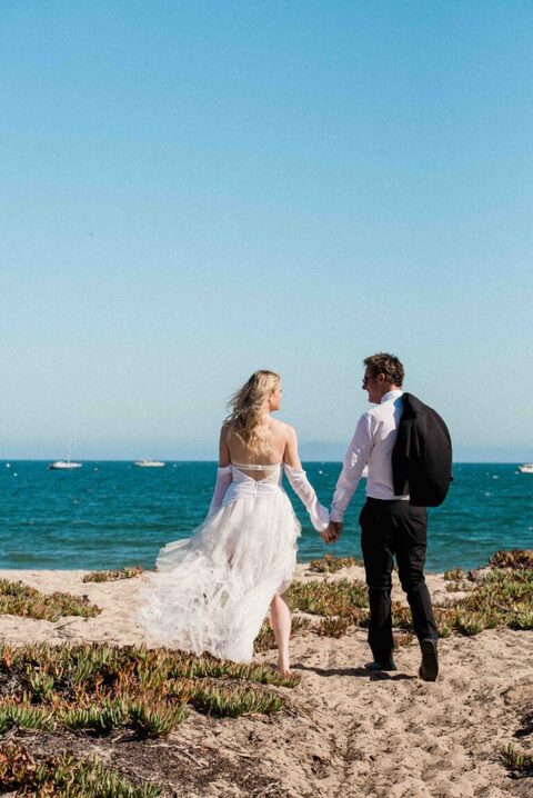 bride and groom looking at each other with pacific ocean in background