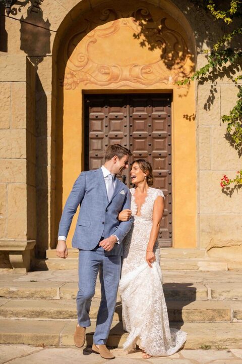 bride and groom laughing in front of decorative door at santa barbara courthouse